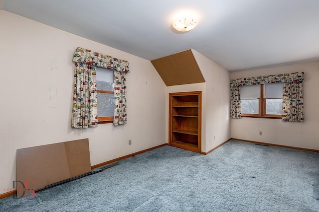 additional living space with lofted ceiling, built in shelves, and carpet floors