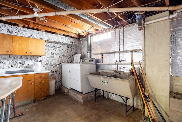 laundry area featuring cabinets, washing machine and clothes dryer, and sink