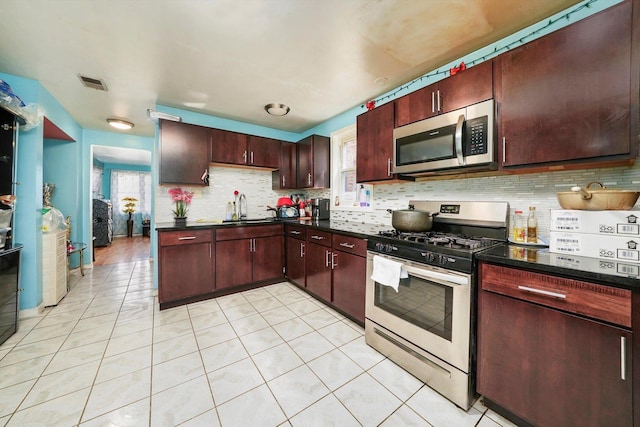 kitchen featuring stainless steel appliances, light tile patterned flooring, plenty of natural light, and sink