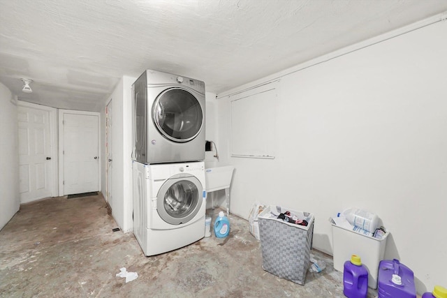 washroom featuring a textured ceiling and stacked washer / dryer