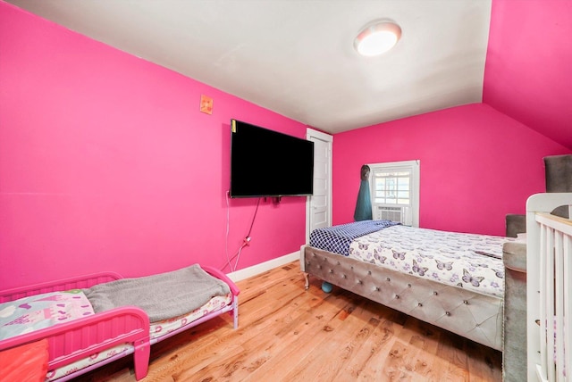 bedroom with wood-type flooring and vaulted ceiling