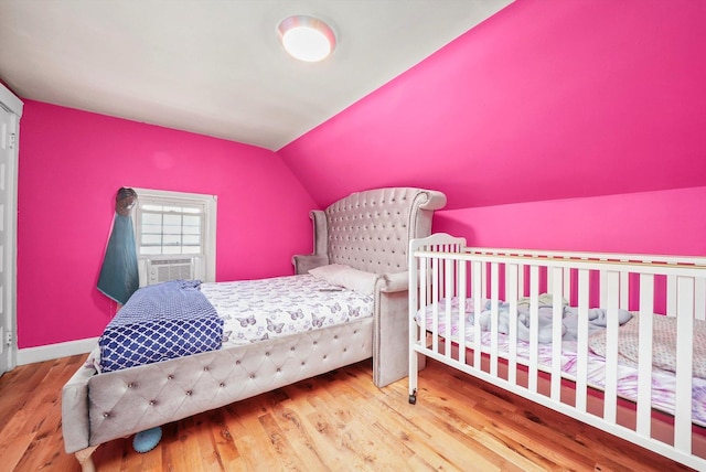 bedroom featuring lofted ceiling, cooling unit, and wood-type flooring