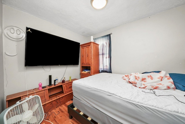 bedroom featuring hardwood / wood-style floors and a textured ceiling