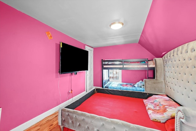 bedroom with vaulted ceiling and hardwood / wood-style floors