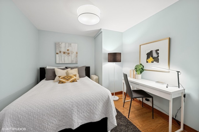 bedroom featuring radiator and light wood-type flooring