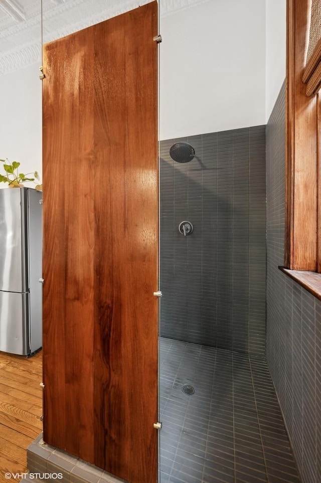 bathroom with hardwood / wood-style flooring and tiled shower