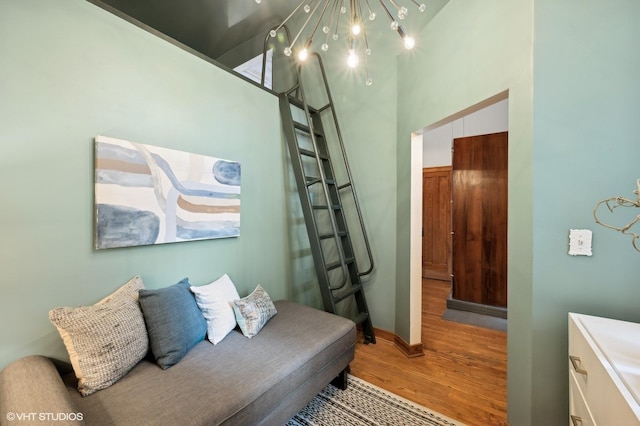 sitting room featuring a towering ceiling and light hardwood / wood-style flooring