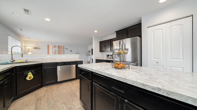 kitchen with stainless steel appliances, light hardwood / wood-style floors, and sink