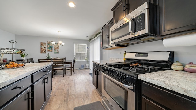 kitchen with appliances with stainless steel finishes, dark brown cabinets, a notable chandelier, light hardwood / wood-style floors, and decorative light fixtures