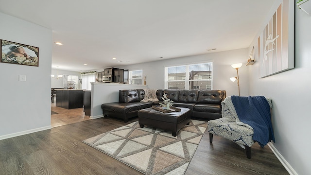 living room with dark wood-type flooring and a chandelier