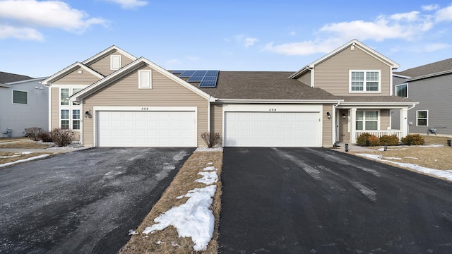 view of front facade with a garage and solar panels