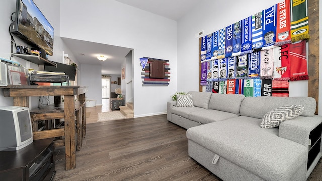 living room with hardwood / wood-style flooring and a towering ceiling