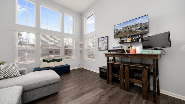 office featuring a towering ceiling and dark hardwood / wood-style floors