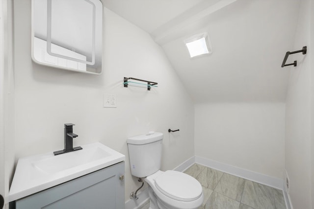 bathroom featuring lofted ceiling, vanity, and toilet