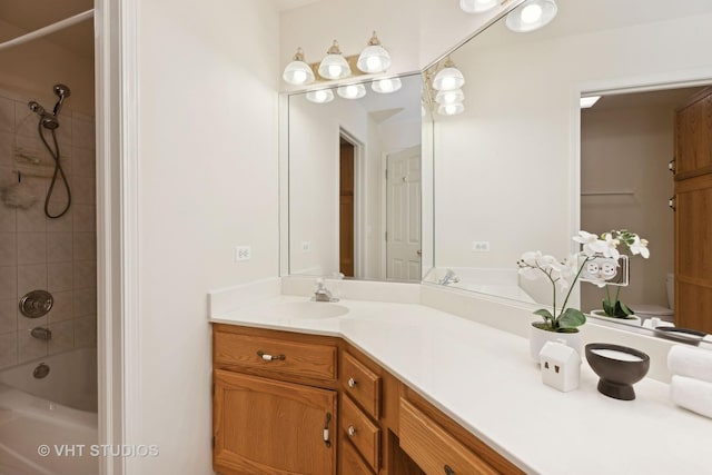 bathroom with tiled shower / bath and vanity