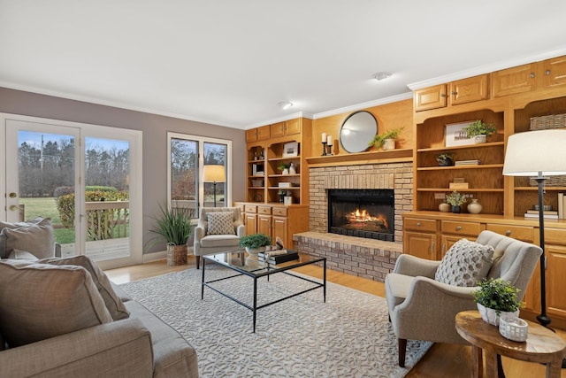 living room with ornamental molding, a brick fireplace, a healthy amount of sunlight, and light hardwood / wood-style floors