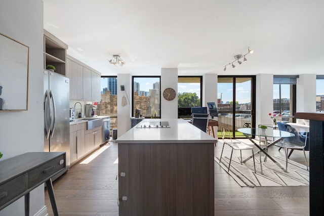 kitchen with floor to ceiling windows, a center island, stainless steel appliances, hardwood / wood-style floors, and backsplash