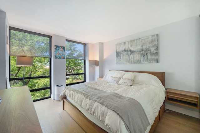 bedroom featuring hardwood / wood-style floors and expansive windows