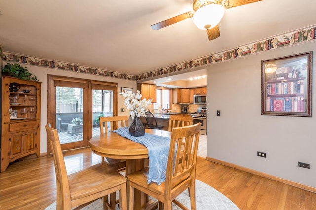 dining space with ceiling fan and light hardwood / wood-style flooring