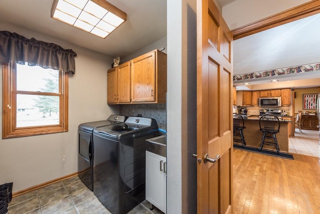 washroom with cabinets, separate washer and dryer, and light tile patterned floors