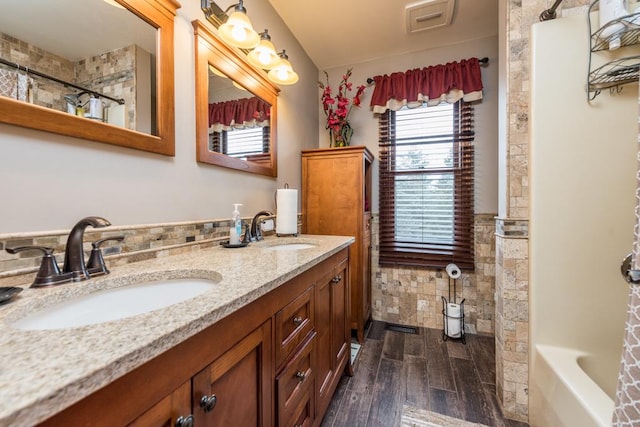 bathroom featuring wood-type flooring, shower / washtub combination, and vanity