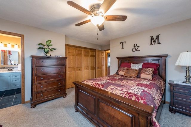 carpeted bedroom featuring connected bathroom, a closet, and ceiling fan