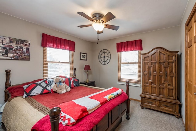 bedroom with ceiling fan, light colored carpet, and multiple windows