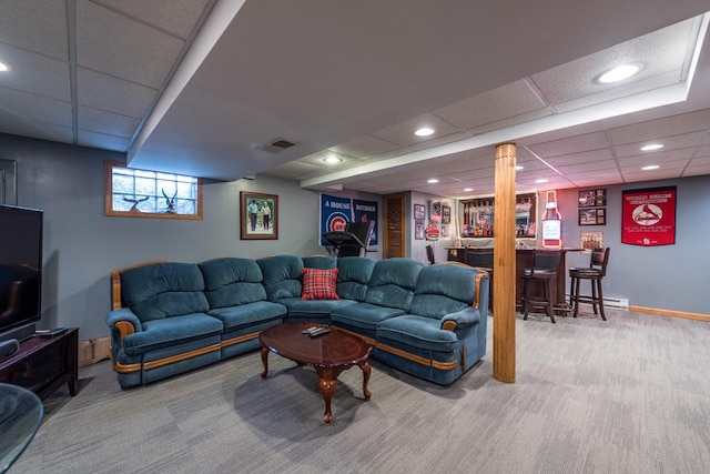 carpeted living room with bar and a paneled ceiling