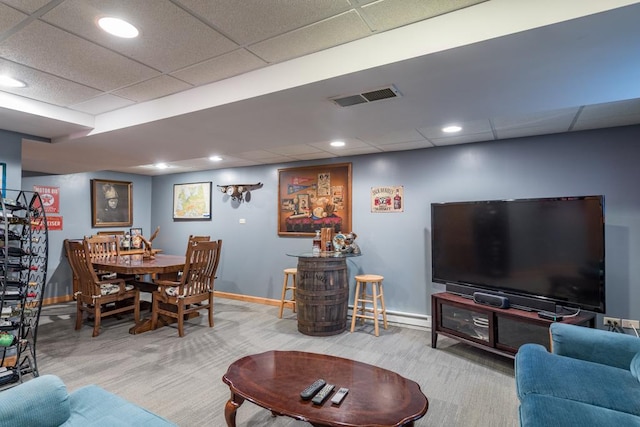 carpeted living room with a drop ceiling