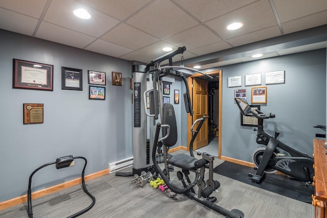 workout area with a paneled ceiling and baseboard heating