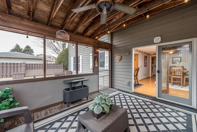 sunroom / solarium with lofted ceiling with beams, wooden ceiling, and ceiling fan