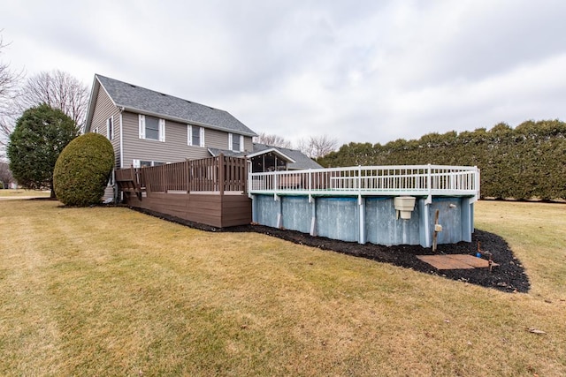 view of pool featuring a lawn and a deck