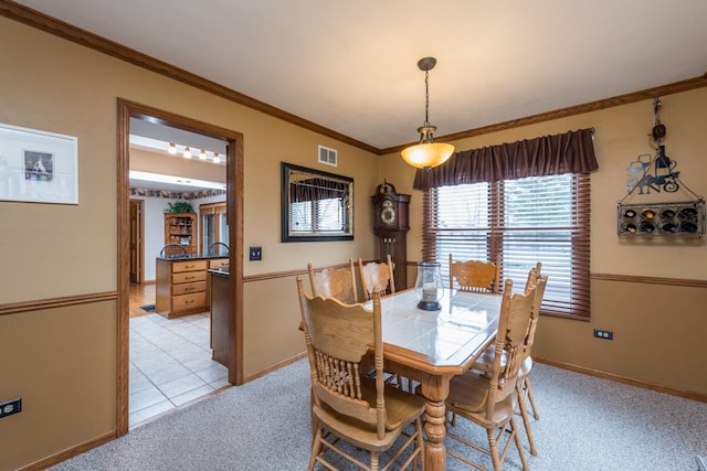 carpeted dining space featuring crown molding