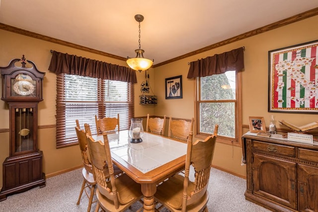 dining room with ornamental molding and light carpet