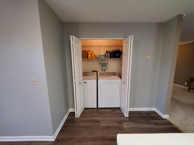 clothes washing area featuring washing machine and clothes dryer and dark hardwood / wood-style floors