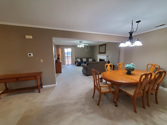 carpeted dining space with ceiling fan and ornamental molding