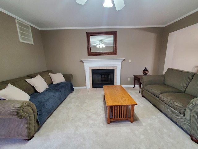 living room with a tiled fireplace, ornamental molding, ceiling fan, and carpet flooring