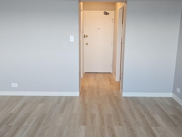 hallway with light hardwood / wood-style floors