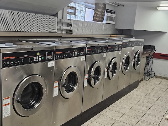 laundry area with separate washer and dryer and light tile patterned floors