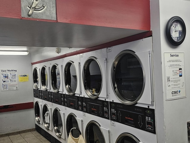 laundry area featuring stacked washer and dryer, washing machine and clothes dryer, and light tile patterned floors