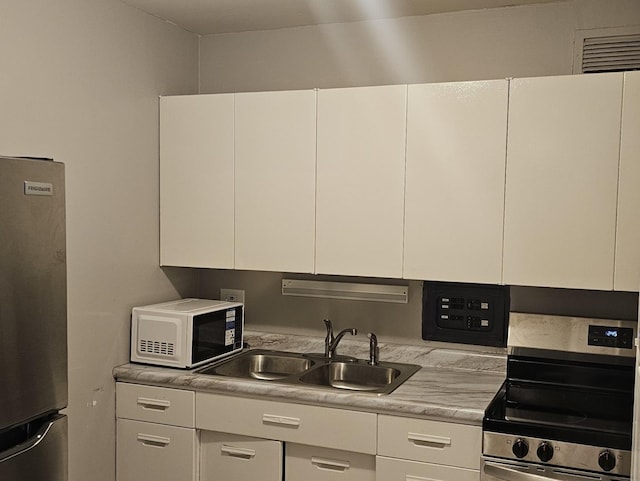 kitchen with white cabinetry, sink, and appliances with stainless steel finishes