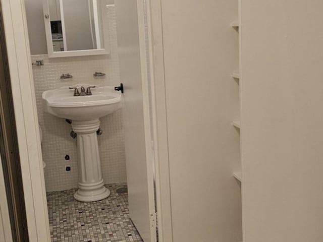 bathroom featuring tile patterned floors and tile walls