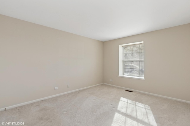 spare room featuring light colored carpet