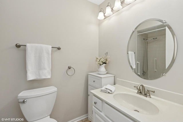 bathroom featuring vanity, toilet, and a tile shower