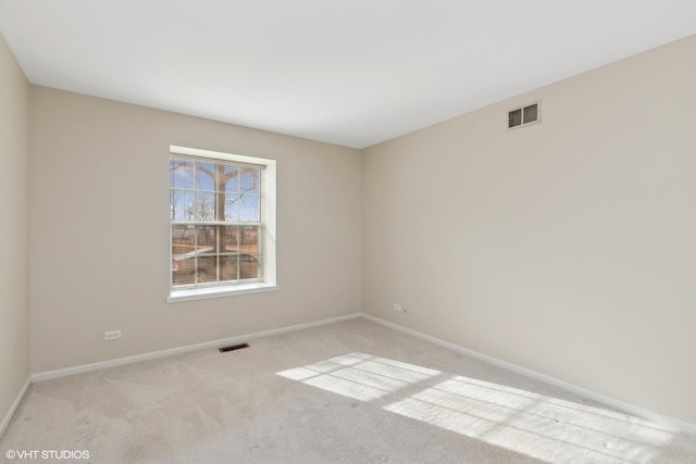 spare room featuring light colored carpet