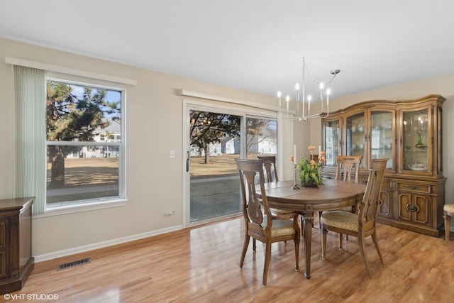 dining room with a notable chandelier and light hardwood / wood-style floors