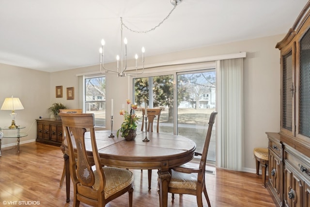 dining space featuring light hardwood / wood-style floors and a notable chandelier