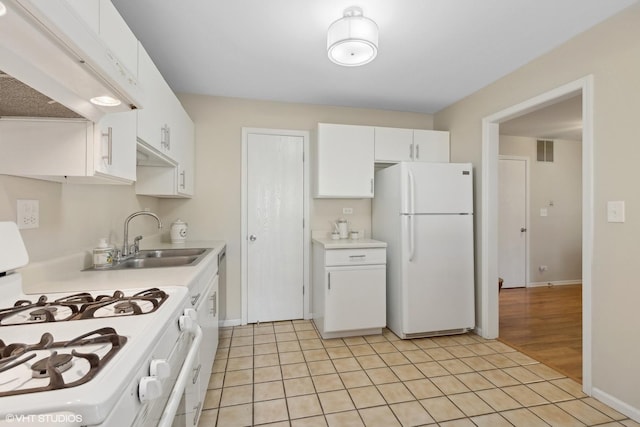 kitchen featuring sink, white cabinetry, light tile patterned floors, white appliances, and range hood