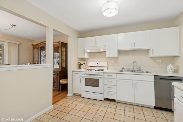 kitchen with light tile patterned floors, sink, dishwasher, white cabinetry, and white gas range