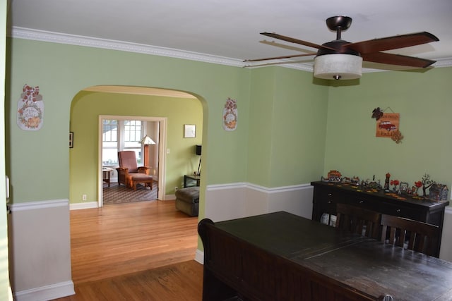 dining space with crown molding, ceiling fan, and wood-type flooring